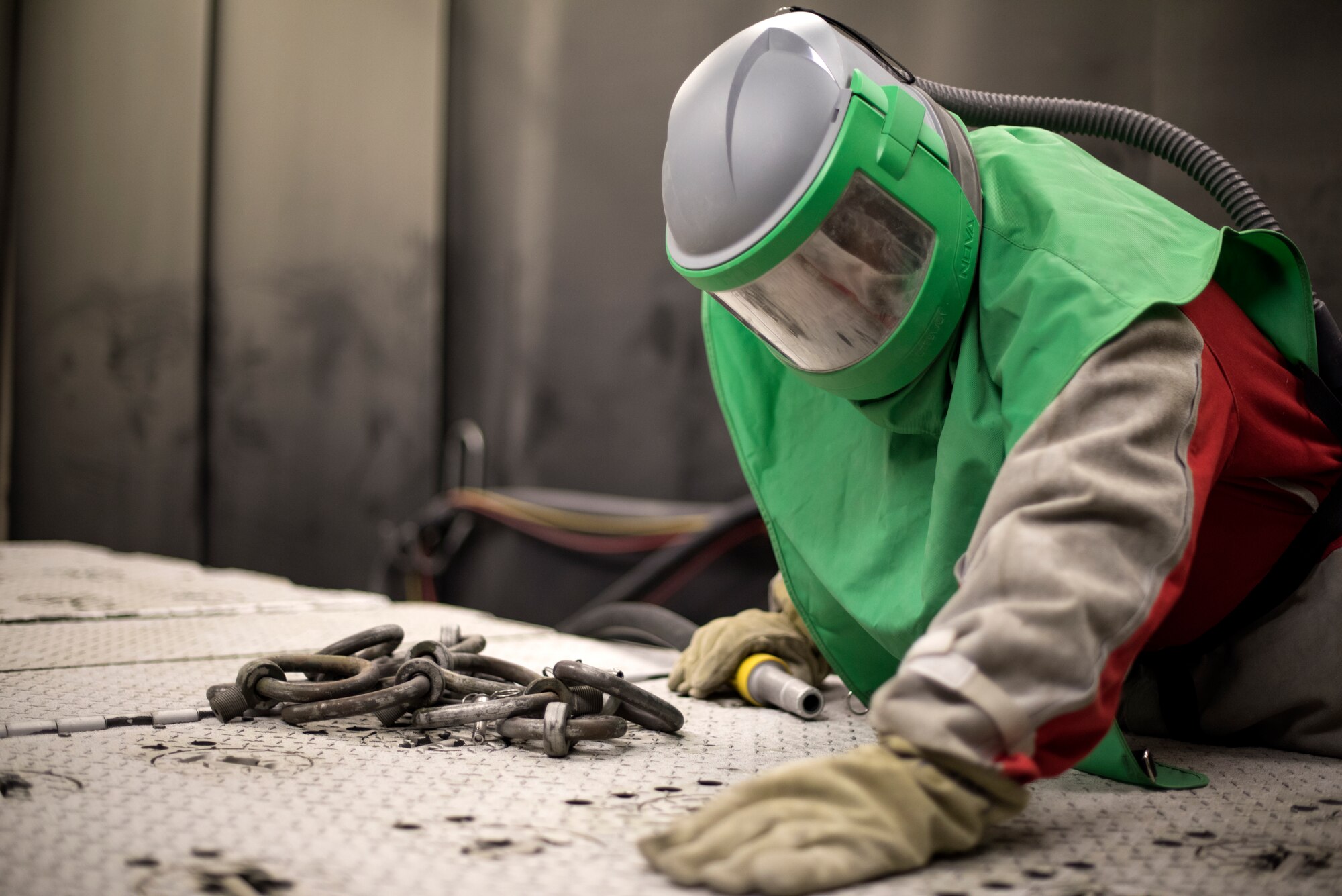 A 48th Equipment Maintenance Squadron Corrosion Control Section Airman uses a walk-in blaster to remove defective coating on a munitions trailer at Royal Air Force Lakenheath, England, Feb. 20, 2018. Defective coatings must be removed before an asset can be repainted. (U.S. Air Force photo/Senior Airman Malcolm Mayfield)