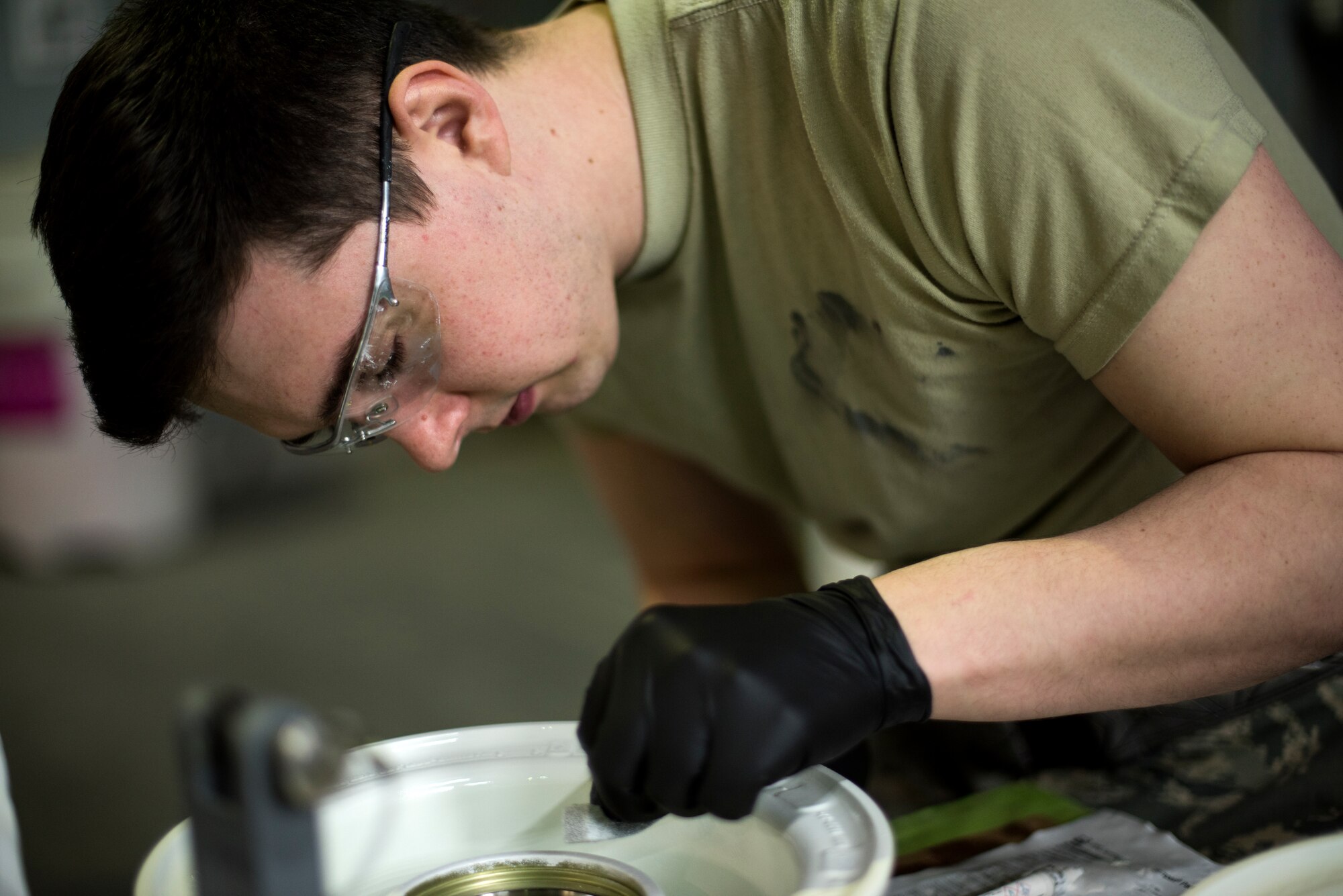 A 48th Equipment Maintenance Squadron Corrosion Control Section Airman manually touches up an F-15 nose landing gear wheel assembly at Royal Air Force Lakenheath, England, Feb. 20, 2018. This is one step in the overhaul process to reinstate an item for mission service. (U.S. Air Force photo/Senior Airman Malcolm Mayfield)