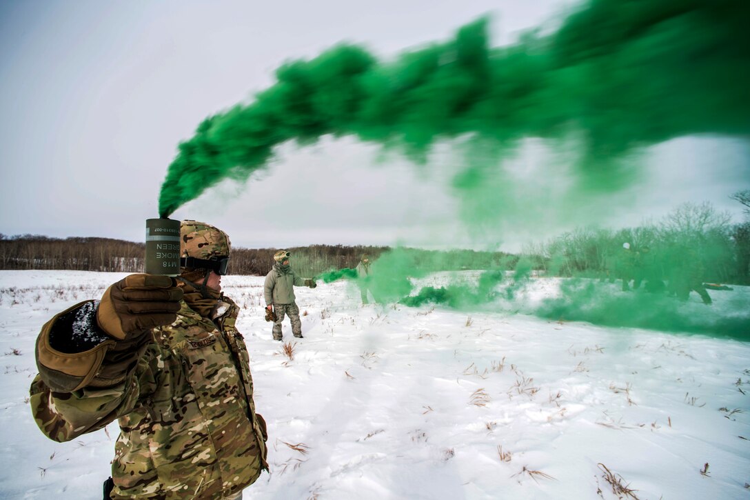 Airmen use green signal smoke during a three-day field training exercise in the Turtle Mountain State Forest, N.D.