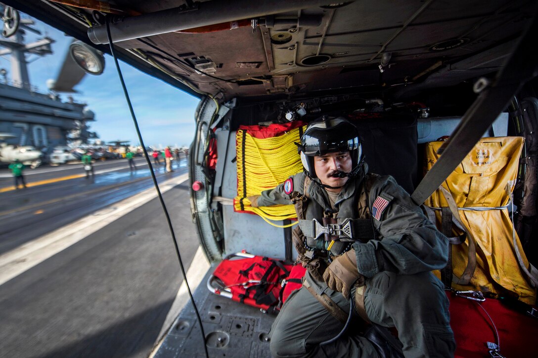 Navy Petty Officer 2nd Class Sebastian Mendieta is ready to launch inside an MH-60S Sea Hawk helicopter during a search and rescue exercise with the aircraft carrier USS Carl Vinson in the South China Sea.