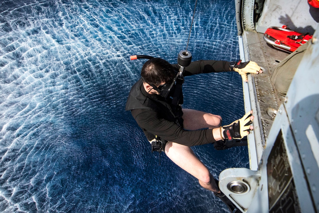 Navy Petty 2nd Class Dalton Branson is lowered from an MH-60S Sea Hawk helicopter during a search and rescue exercise.