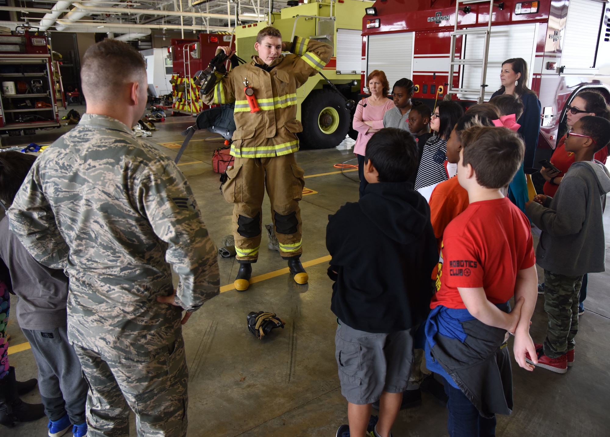 Airman 1st Class Kyle Tolle, 81st Infrastructure Division firefighter, demonstrates how to put on firefighter gear during Biloxi Career Exploration Day at the fire department Feb. 14, 2018, on Keesler Air Force Base, Mississippi. The school-aged children also toured the 334th Training Squadron, 335th TRS and the Trainer Development Center. (U.S. Air Force photo by Kemberly Groue)