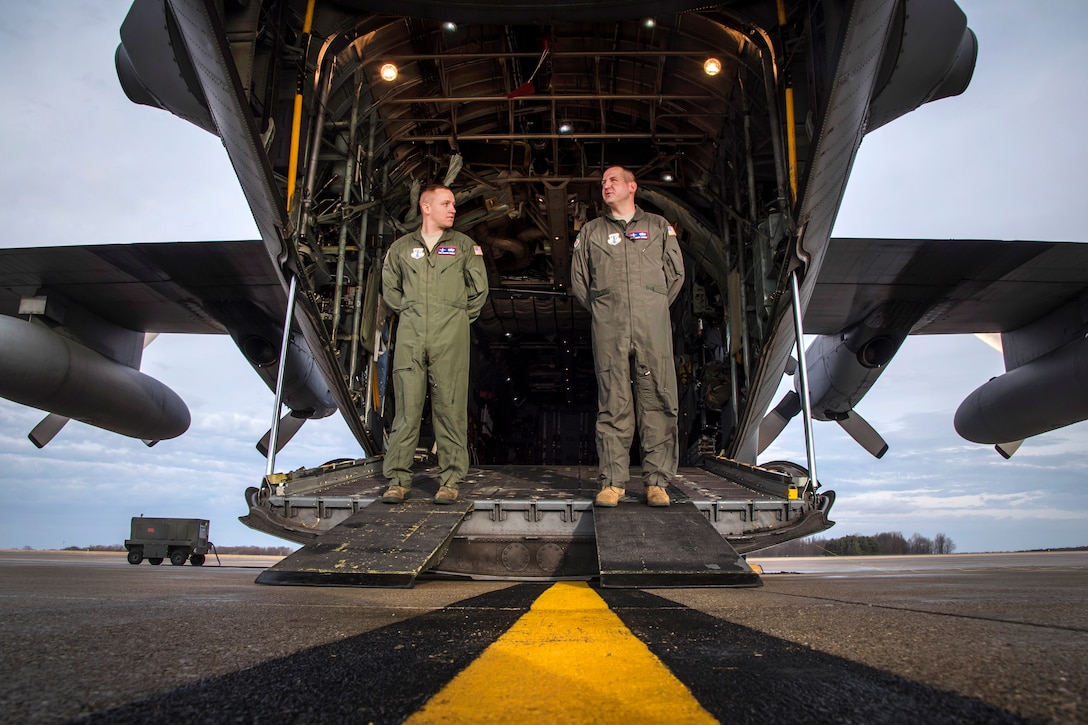 Air Force Master Sgt. Robert Snyder and Staff Sgt. Spencer Magers secure the back ramp and for clearance before takeoff on a C-130H Hercules aircraft.