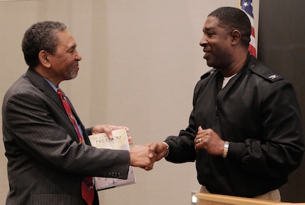 IMAGE: KING GEORGE, Va. (Feb. 14, 2018) - Dr. Frank Smith holds the Dahlgren history book, "The Sound of Freedom," he just received from Capt. Godfrey "Gus" Weekes, Naval Surface Warfare Center Dahlgren Division (NSWCDD) commanding officer, while the two shake hands at the 2018 African American and Black History Month Observance. As the event's keynote speaker, Dr. Smith - Director of the African American Civil War Museum in Washington, DC. - focused on this year's theme, "African Americans in Times of War," which recognizes contributions African Americans made to the nation during times of war from the Revolutionary War to present-day conflicts.