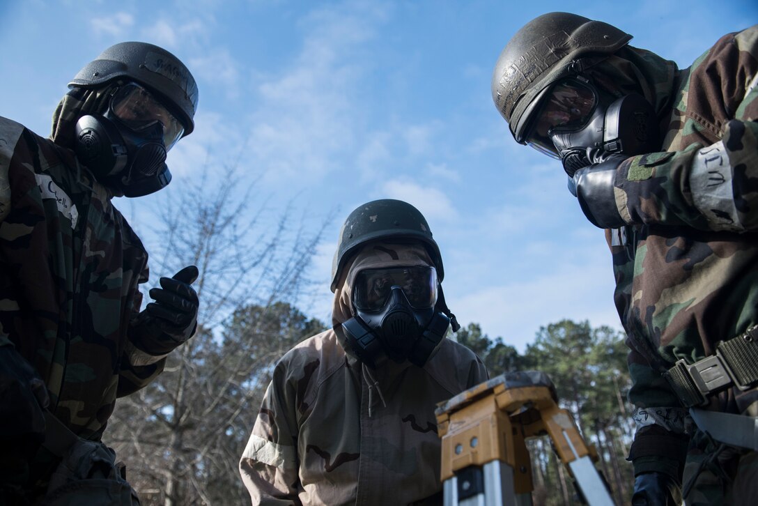 U.S. Airmen look down at a piece of M8 chemical detection paper at Shaw Air Force Base, S.C., Feb. 15, 2018.