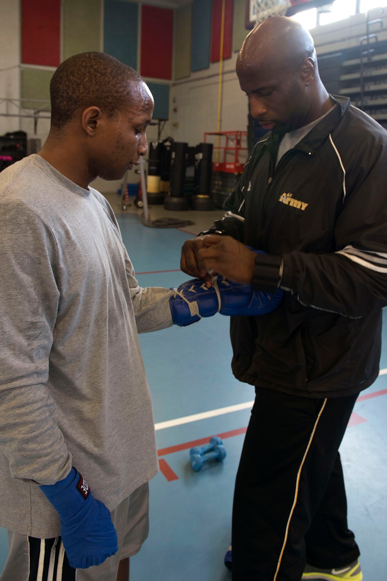 U.S. Army Sgt. 1st Class Andrew Shepherd, battalion supply noncommissioned officer in charge, 1st Battalion, 222nd Regiment, 128th Brigade, ties boxing gloves for U.S. Army Sgt. Darius Lane, helicopter repairer, Detachment 2, B Company, 935th Aviation Support Battalion, in Joint Base Langley-Eustis' Anderson Field House at Fort Eustis, Va., Feb. 15, 2018. Shepherd has been coaching boxing since 2012 and offers classes at Fort Eustis. (U.S. Air Force photo by Airman 1st Class Monica Roybal)