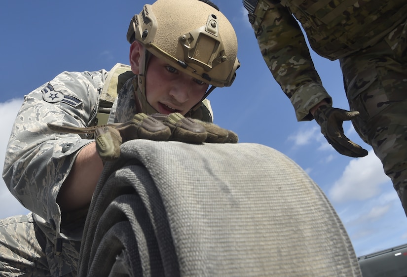 Airman 1st Class Nathan Lynch, 628th Logistics Readiness Squadron fuels distribution operator rolls up a fuel hose while trying out for the Forward Area Refueling Point team here Feb. 15, 2018.