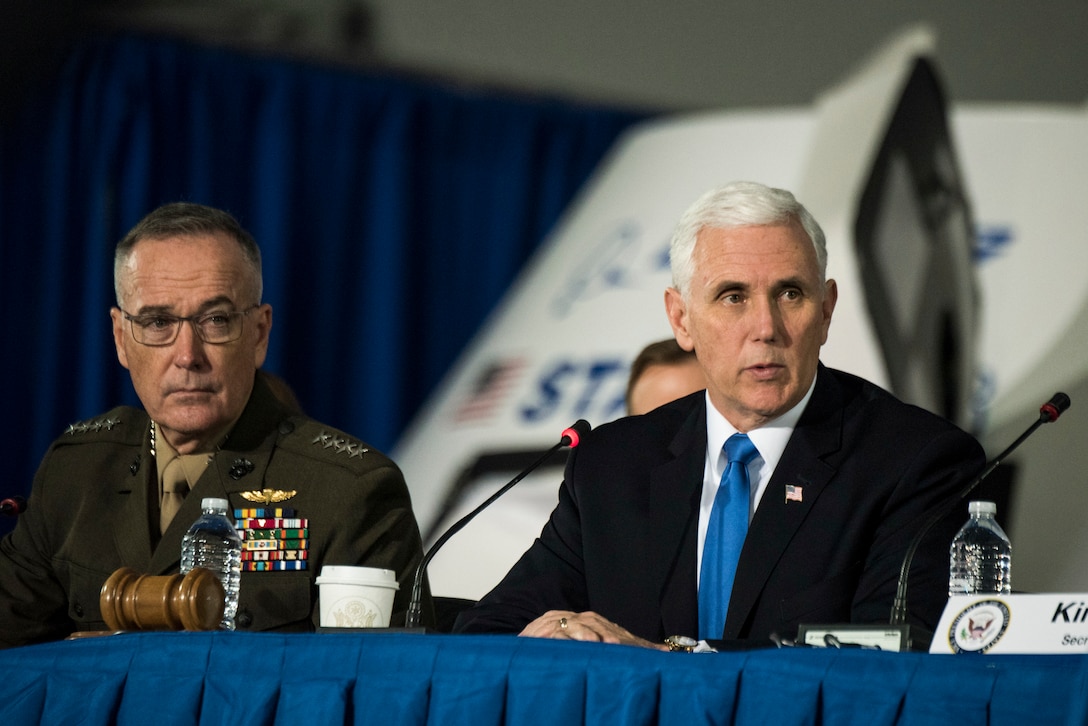 Vice President Mike Pence talks while sitting next to Marine Corps Gen. Joe Dunford at a table.