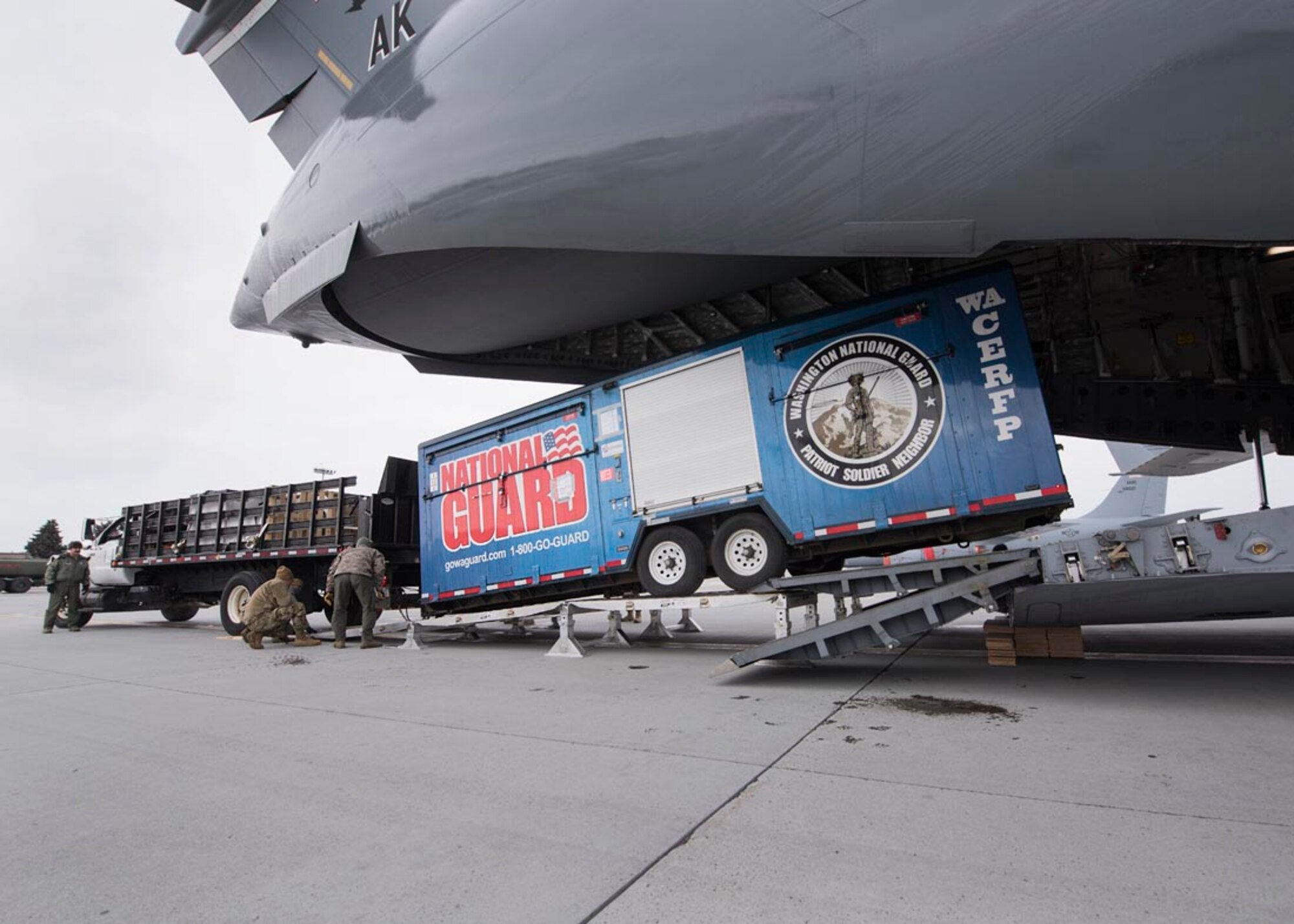 Airmen from the 176th Wing, Alaska Air National Guard and Washington Army Guardsmen load a cargo trailer onto a C-17 Globemaster III February 20, 2018 at Fairchild Air Force Base, Wash. Nearly 250 Air and Army Guardsmen from Alaska, Colorado, Connecticut, Indiana, South Dakota, Utah, and Washington are slated to participate in Exercise Arctic Eagle 2018 in Valdez, Alaska through the end of February. Arctic Eagle is a scenario-based exercise in which Guardsmen will conduct Homeland Response Force (HRF) and Chemical, Biological, Radiological, Nuclear and High Yield Explosive (CBRNE) Enhanced Response Force Package (CERFP) operations in a cold weather environment. (U.S. Air National Guard photo by Staff Sgt. Rose M. Lust/Released)