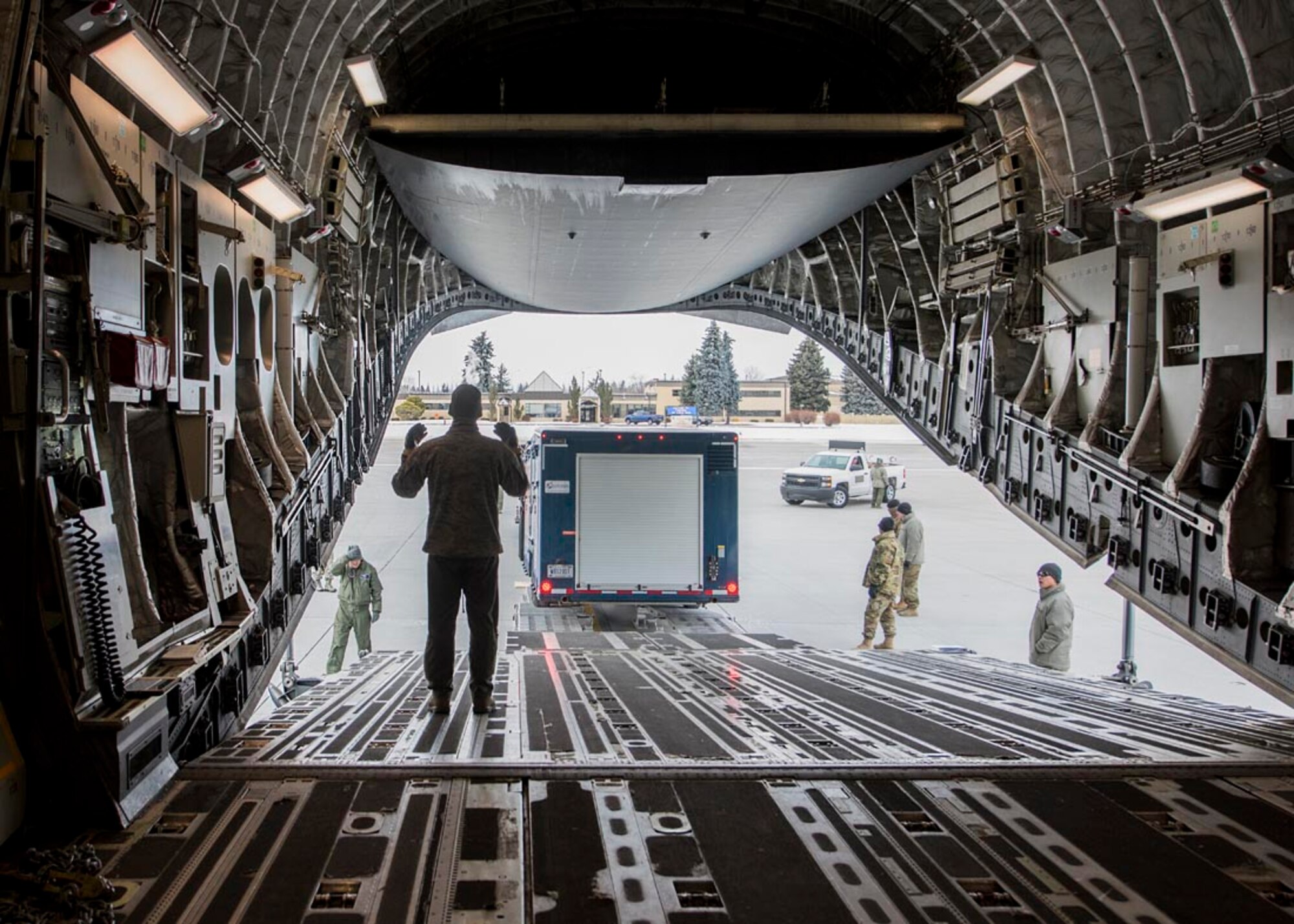 A loadmaster from the 176th Wing, Alaska Air National Guard, helps guide a cargo trailer onto a C-17 Globemaster III February 20, 2018 at Fairchild Air Force Base, Wash. Personnel, equipment, and vehicles are scheduled to be transported to Valdez, Alaska for use in Exercise Arctic Eagle February 20-27. (U.S. Air National Guard photo by Staff Sgt. Rose M. Lust/Released)
