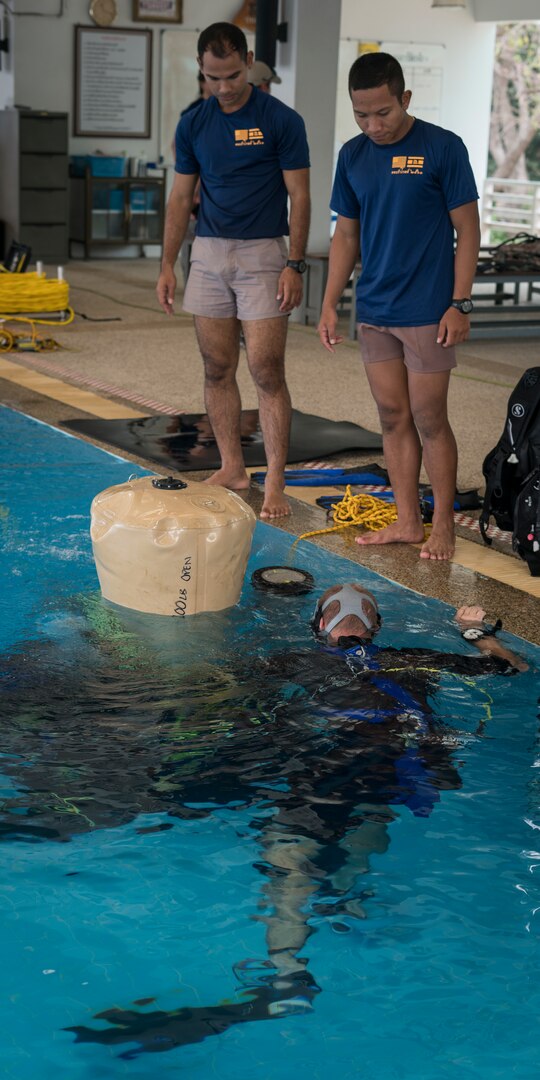 Royal Thai Navy sailors assist U.S. Navy Diver 1st Class John Reinemund, assigned to Mobile Diving and Salvage Unit 1, as he maneuvers a lift bag in the RTN Dive School pool in Sattahip, Thailand for Exercise Cobra Gold Feb. 19, 2018. Cobra Gold 18 provides a venue for the United States, allied and partner nations to advance interoperability and increase partner capacity in planning and executing complex and realistic multinational force and combined task force operations.