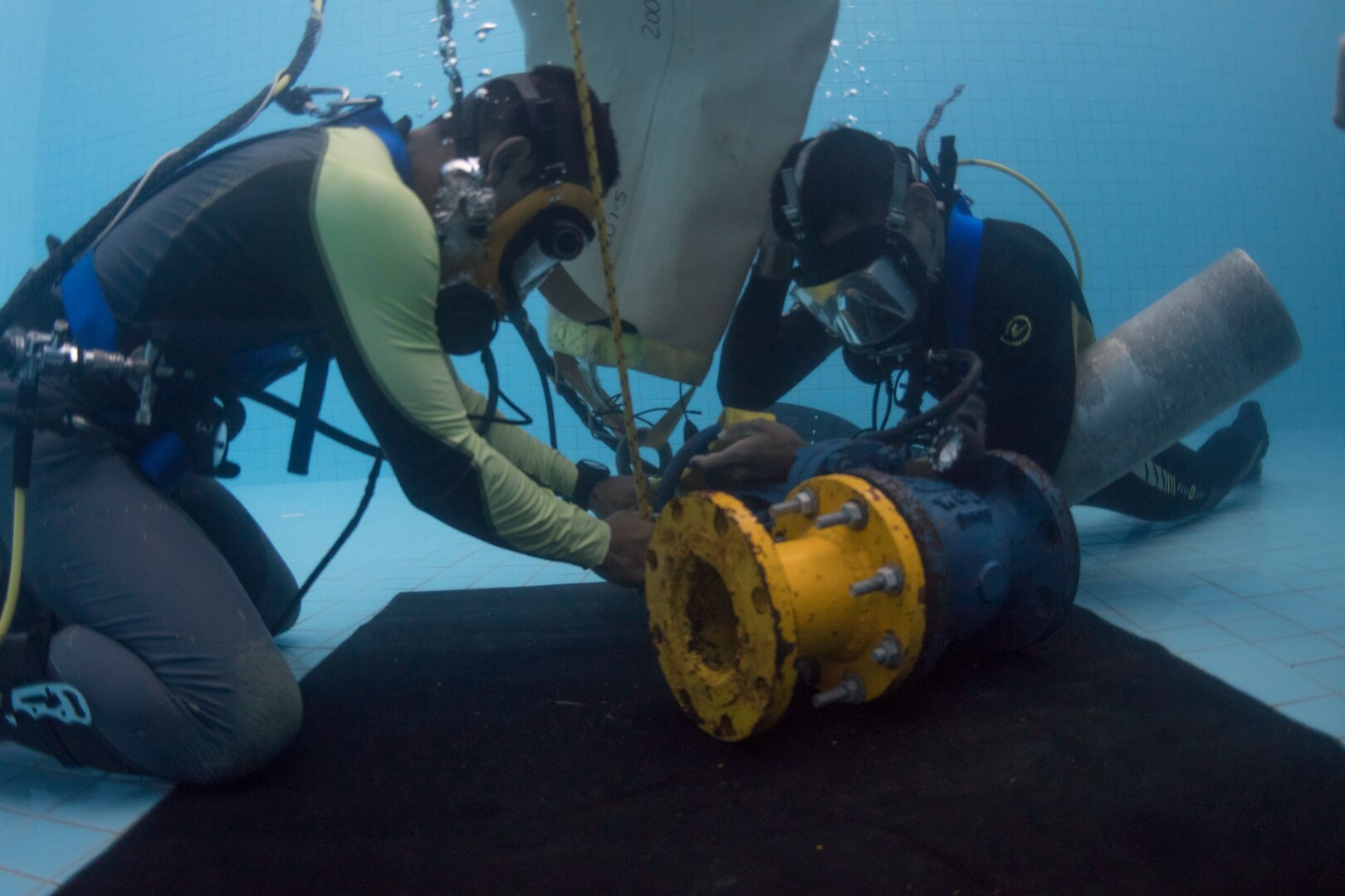Royal Thai Navy sailors attach a lift bag to a valve flange in the RTN Dive School pool in Sattahip, Thailand during Exercise Cobra Gold Feb. 19, 2018. Cobra Gold 18 provides a venue for the United States, allied and partner nations to advance interoperability and increase partner capacity in planning and executing complex and realistic multinational force and combined task force operations.