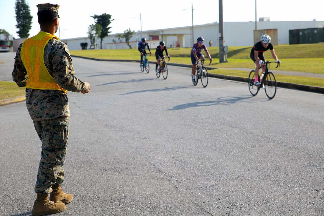 A Marine posts as a road guard during a bike race Feb. 18 aboard Camp Kinser, Okinawa, Japan. The race brought U.S. and local communities across Okinawa together to take part in friendly competition. About 130 racers participated in the first of four bike races held on Marine Corps bases in Okinawa throughout the year. (U.S. Marine Corps photo by Pfc. Nicole Rogge)