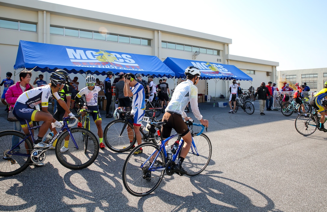 Racers gather at the finish line for post-race snacks after a bike race Feb. 18 aboard Camp Kinser, Okinawa, Japan. The race brought U.S. and local communities across Okinawa together to take part in friendly competition. Racers on road bikes completed five laps around Camp Kinser’s base for a total of 42 km. Mountain bikers completed two laps for a total of 17 km. (U.S. Marine Corps photo by Pfc. Nicole Rogge)
