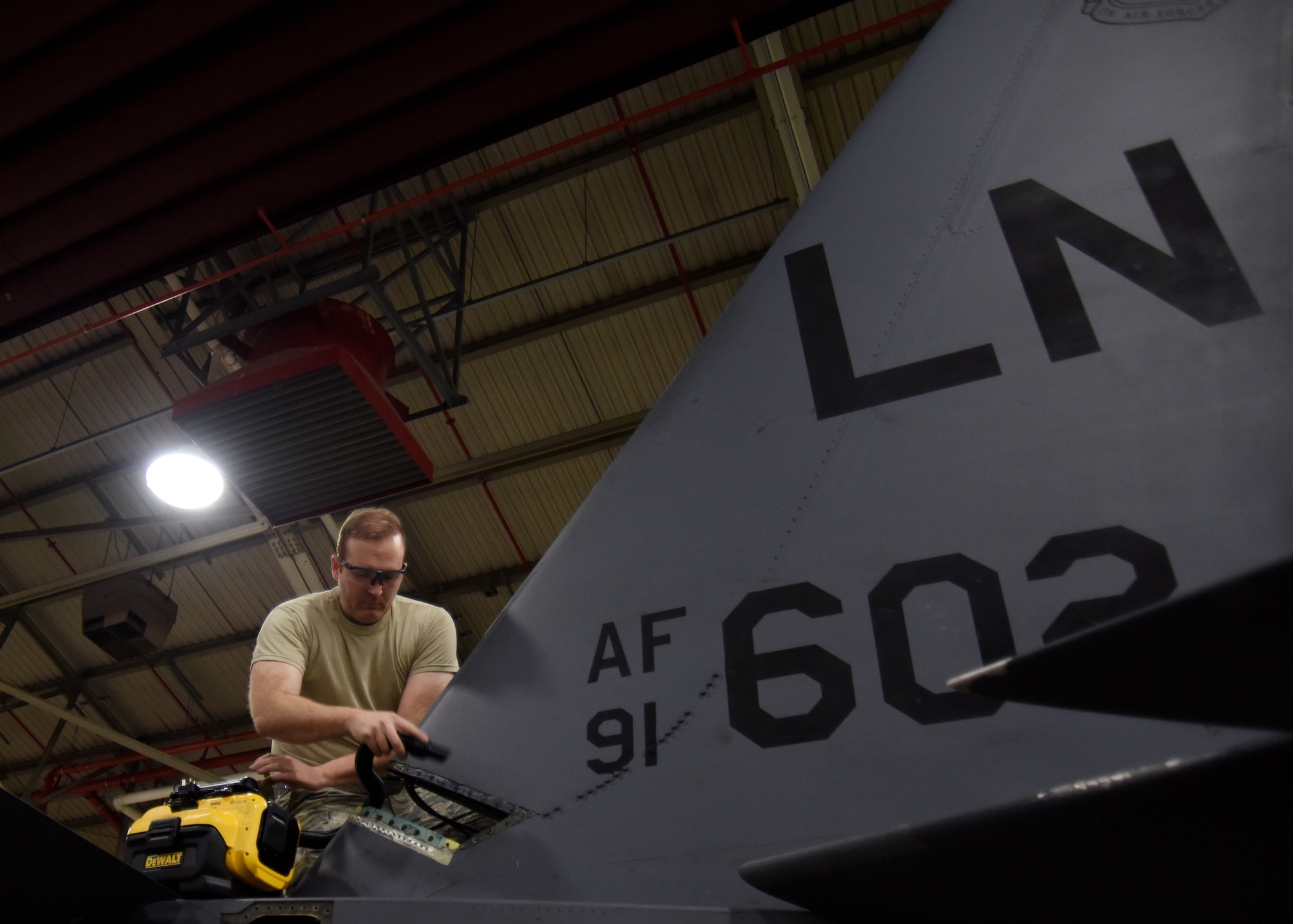 Staff Sgt. Eric Pate, 48th Equipment Maintenance Squadron aircraft structural maintenance craftsman, vacuums his work space at Royal Air Force Lakenheath, England, Feb. 14. During phase inspections, crew chiefs complete a comprehensive inspection of the aircraft. (U.S. Air Force photo/Senior Airman Abby L. Finkel)