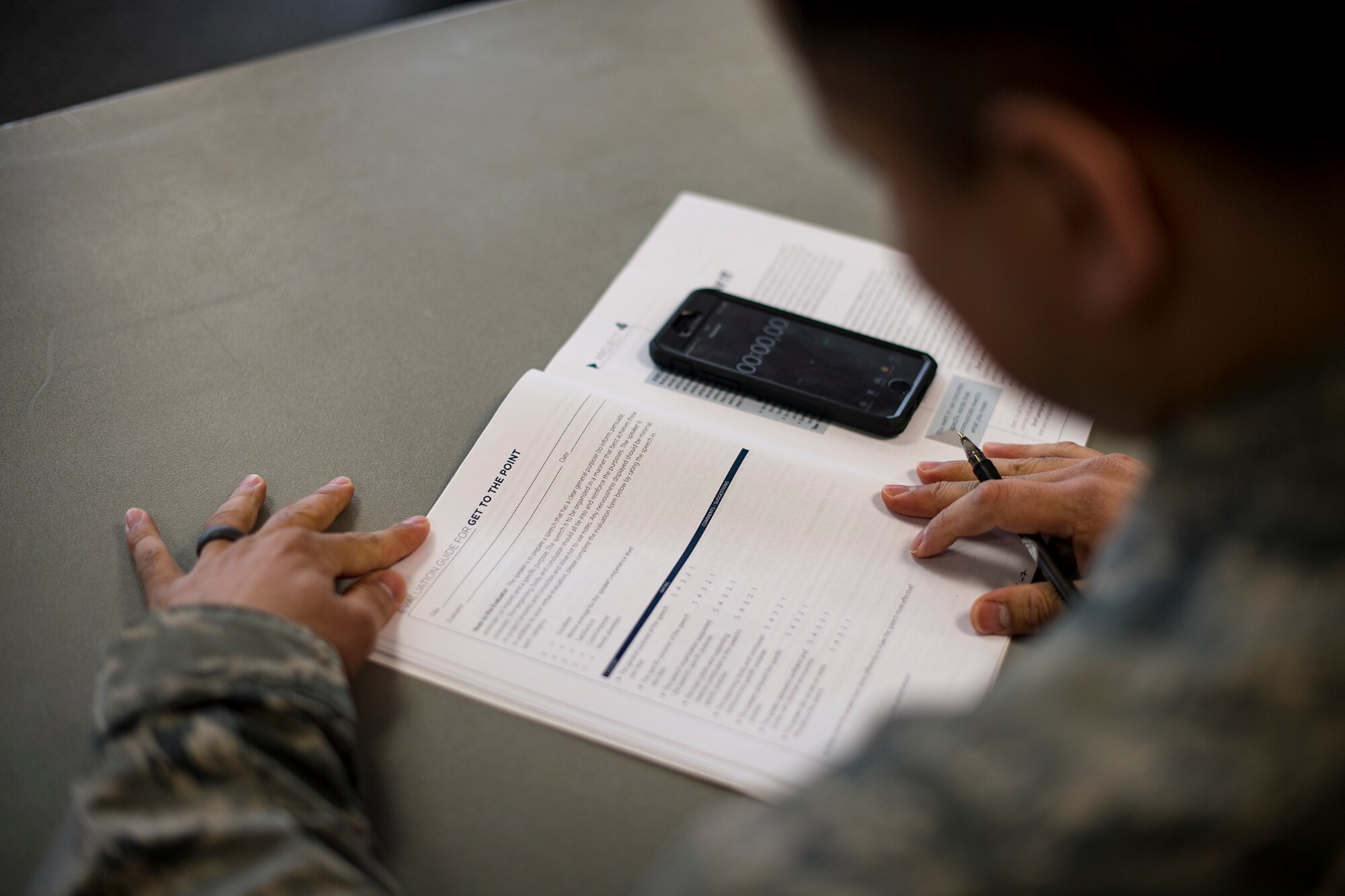U.S. Air Force Senior Master Sgt. Hugo Caballero, Ramstein Speakers Association senior mentor, grades a speech during a Toastmasters meeting at the Southside Chapel on Ramstein Air Base, Feb. 20, 2018. Toastmasters RSA is an organization that gives individuals an opportunity to improve their public speaking skills. (U.S. Air Force photo by Senior Airman Devin Boyer)