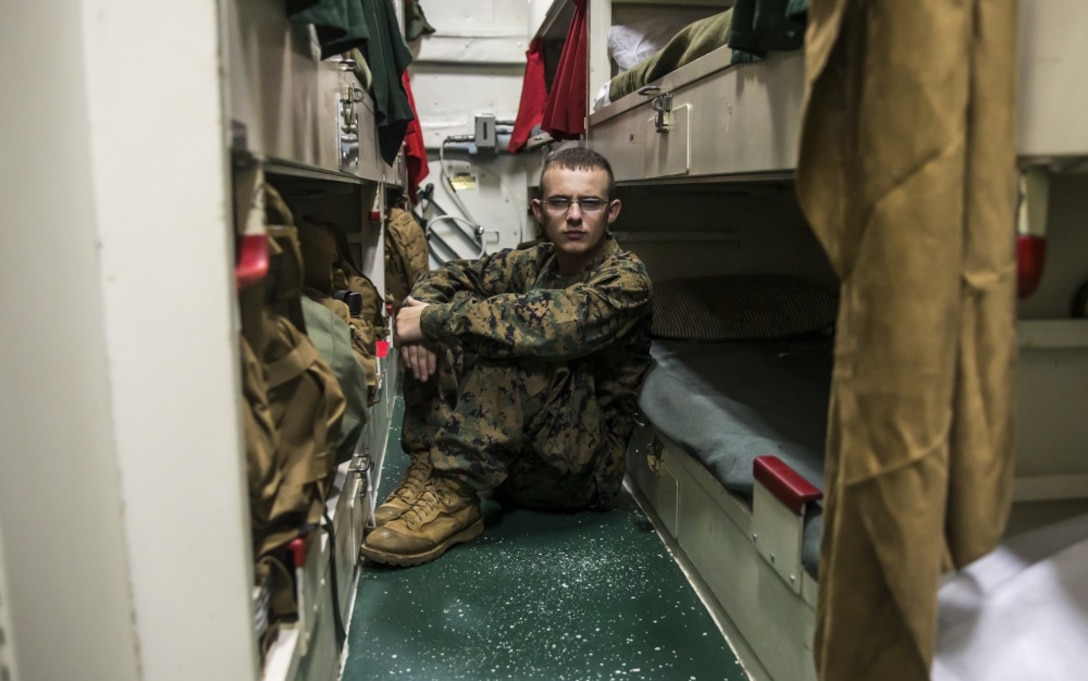 A Marine sits in his berth aboard an amphibious assault ship.