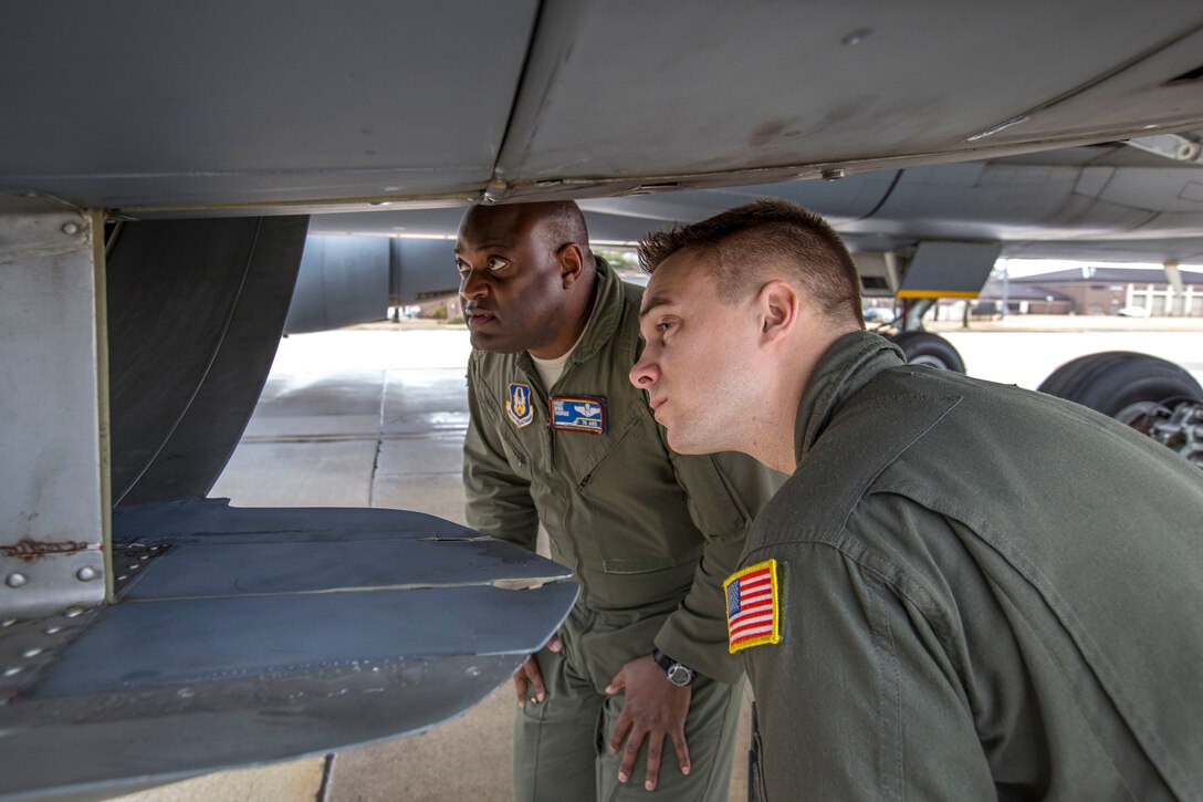 Air Force Master Sgt. Greg L. Thomas, back, and Staff Sgt. Ryan L. Woods inspect a KC-10 Extender aircraft turbofan engines.