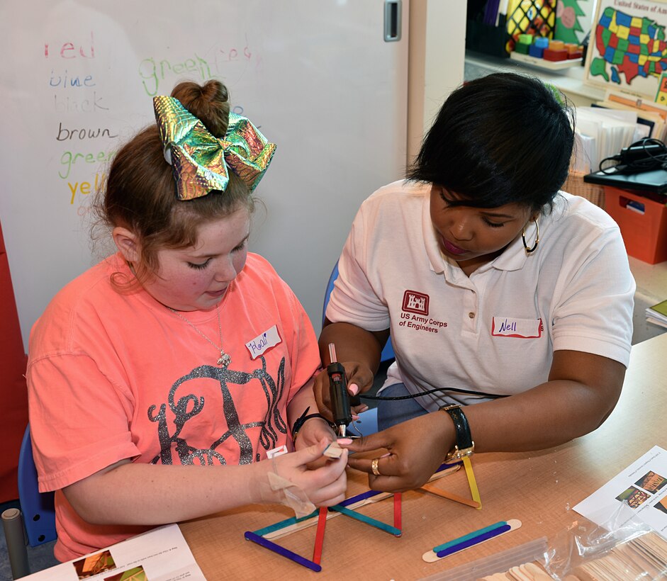 U.S. Army Corps of Engineers, Mobile District, Contracat Specialist Lanell Roberts works with a child at the University of South Alabama Children’s & Women’s Hospital, Feb. 20, to construct a bridge out of Popsicle sticks. The event was part of the district’s National Engineers Week outreach program to teach school-age children the importance of science, technology, engineering and math (STEM).