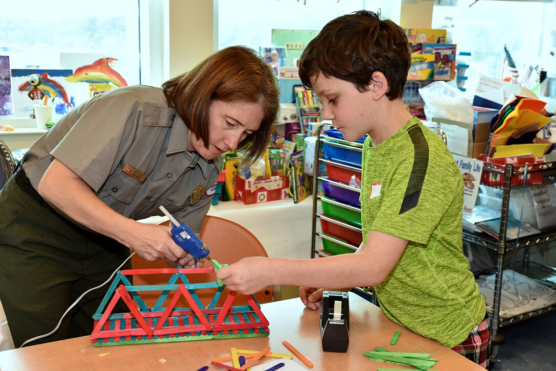 U.S. Army Corps of Engineers, Mobile District, Natural Resources Program Manager Amy Cobb-Williams works with a child at the University of South Alabama Children’s & Women’s Hospital, Feb. 20, to construct a bridge out of Popsicle sticks. The event was part of the district’s National Engineers Week outreach program to teach school-age children the importance of science, technology, engineering and math (STEM).