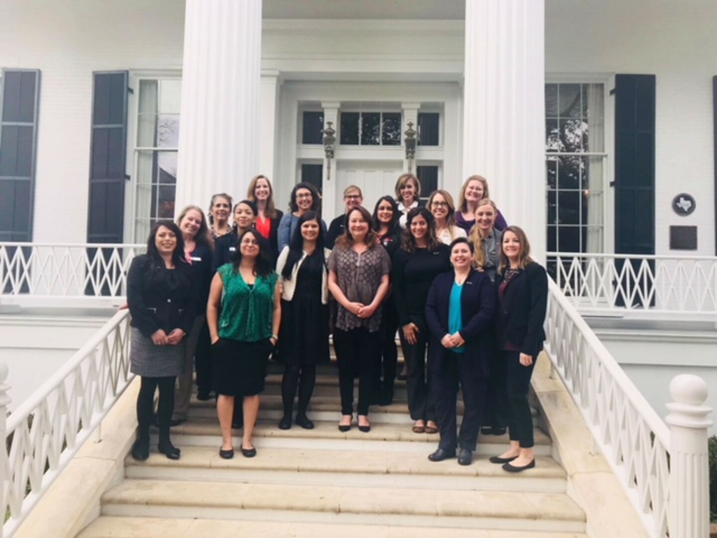 Volunteers from the Key Spouse Program stand in front of the Governor's mansion in Austin, Texas after meeting with the First Lady of Texas Cecilia Abbott (pictured center) January 2018.  The group informed Mrs. Abbott about the assistance volunteers provide for newly arrived Air Force families at Joint Base San Antonio.