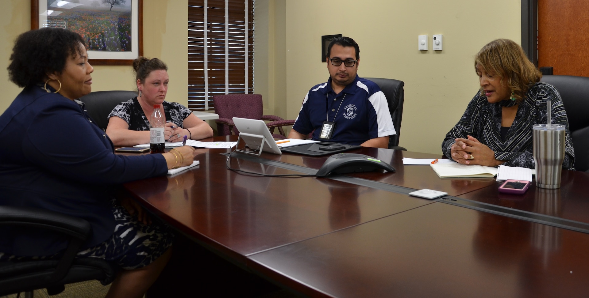 (From left) Tracy Williams, K.A. Boles, Samuel Colton and Regina Espinosa discuss transferring contracts to another office during a meeting Jan. 31 at the Mission and Installation Contracting Command-Fort Sam Houston contracting office at Joint Base San Antonio-Fort Sam Houston. Williams is a contract specialist with the MICC-Fort Sam Houston Reserve Support Division, and Boles is system administrator at MICC-Fort Sam Houston. Colton and Espinosa are contracting officers also with the division.