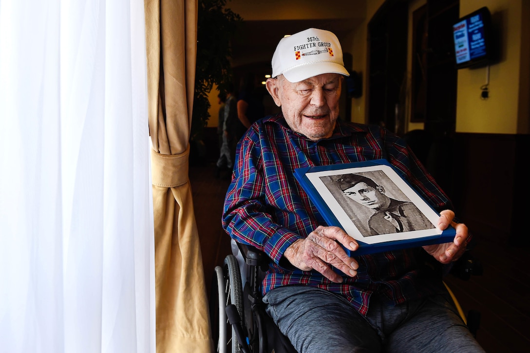 Retired Air Force Brig. Gen. Chuck Yeager looks at a photo of himself from the 1940s.