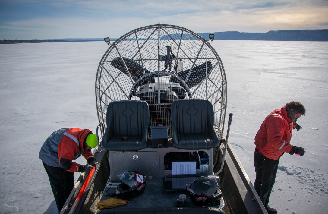 two men use an airboat to take ice measurements