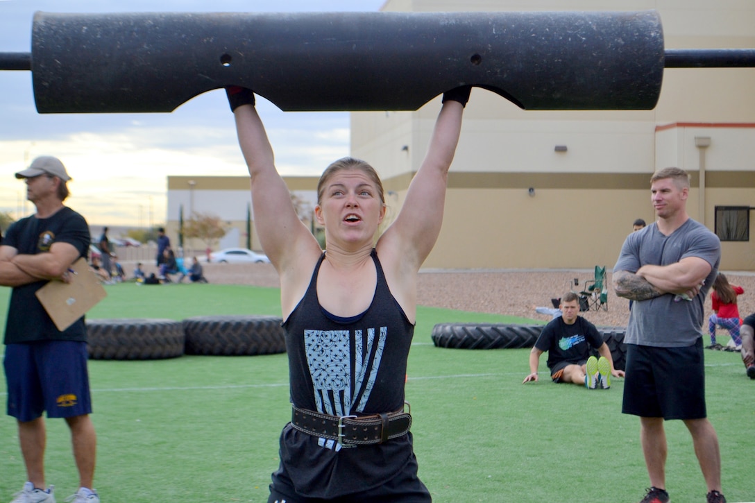 A women lifts weights over her head.