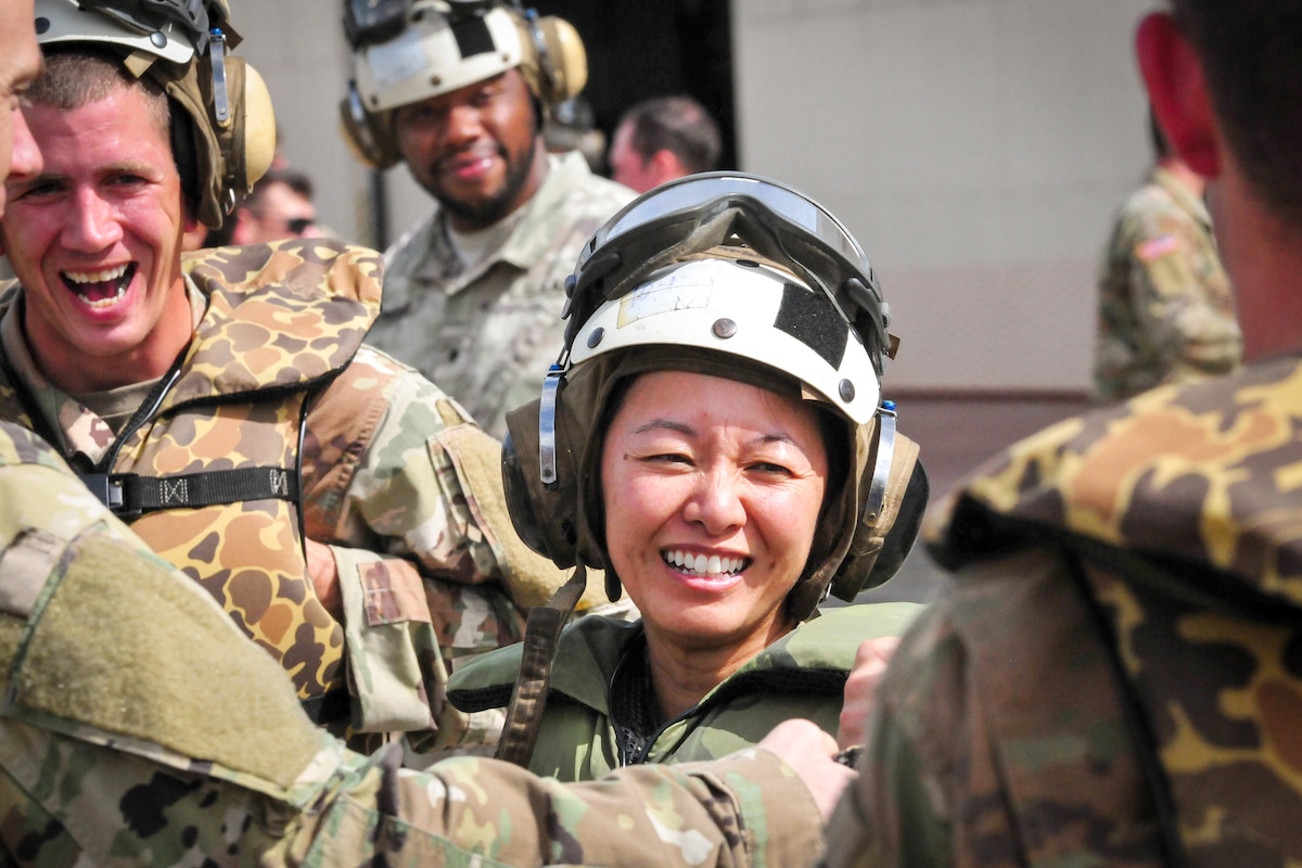 A soldier laughs with other soldiers.