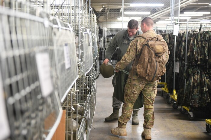 Staff Sgt. J.P. Caudrillier fills Senior Airman Patrick Schilling's mobility bag during a readiness exercise Jan. 29, 2018, at Hill Air Force Base, Utah. Airmen simulated the process of filling their mobility bags, weapon issue, and going through a pre-deployment function line. (U.S. Air Force photo by Cynthia Griggs)