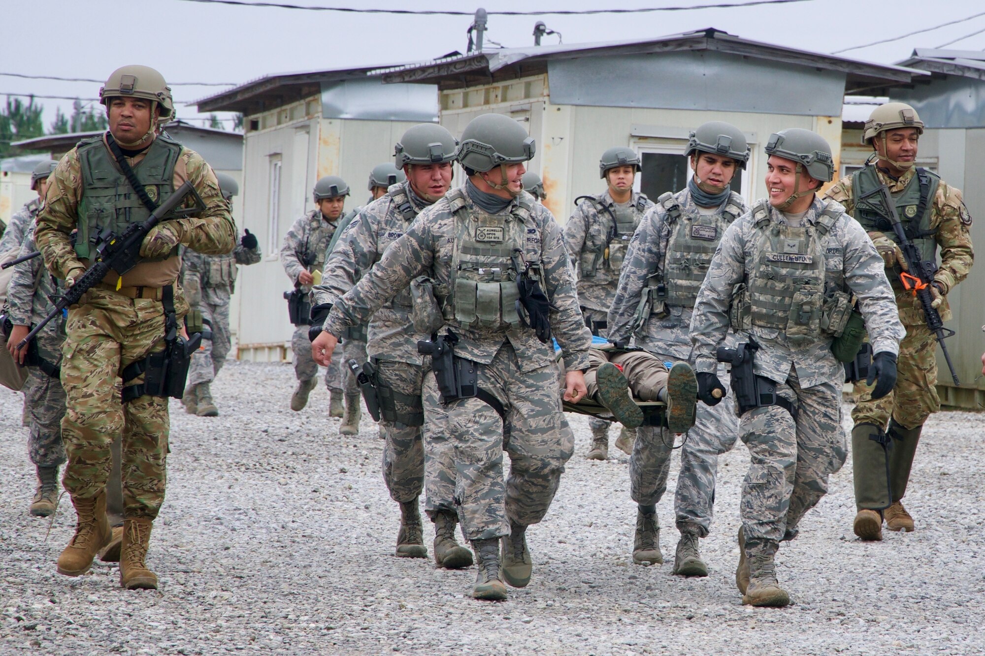 Members of the Mississippi Department of Wildlife, Fisheries and Parks Special Response Team escort members of the 154th Security Forces Squadron while they simulate the transport of a wounded civilian in a Patriot South exercise, Feb. 13, 2018, at Camp Shelby, Mississippi.