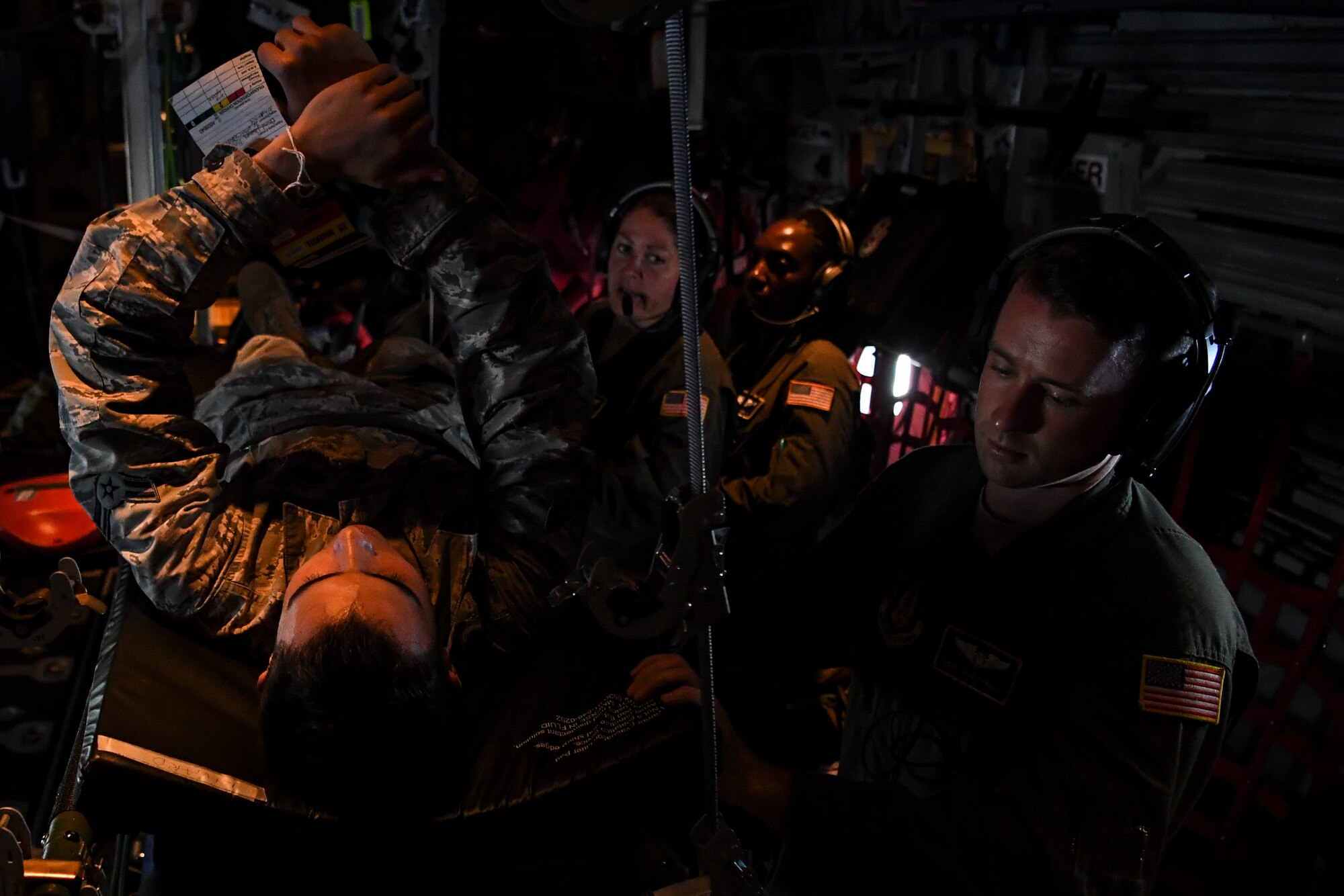 (Right) U.S. Air Force Staff Sgt. David Francis, 349th Aeromedical Evacuation Squadron technician, treats a simulated patient during an aeromedical mission over Rota, U.S. Commonwealth of the Northern Mariana Islands, during exercise COPE NORTH 18, Feb. 19.