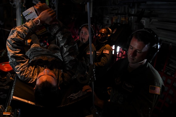 (Right) U.S. Air Force Staff Sgt. David Francis, 349th Aeromedical Evacuation Squadron technician, treats a simulated patient during an aeromedical mission over Rota, U.S. Commonwealth of the Northern Mariana Islands, during exercise COPE NORTH 18, Feb. 19.