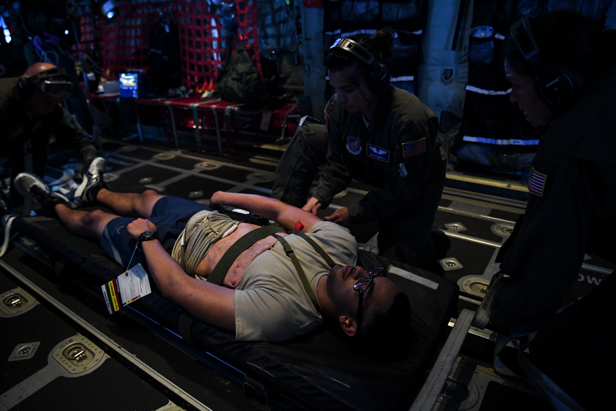 (Right) U.S. Air Force Major Catherine Paterson, 439th Aeromedical Evacuation Squadron, and Captain   Betsy Mayes, 349th Aeromedical Evacuation Squadron flight nurse, treat a simulated patient during an aeromedical mission over Rota, U.S. Commonwealth of the Northern Mariana Islands, during exercise COPE NORTH 18, Feb. 19.