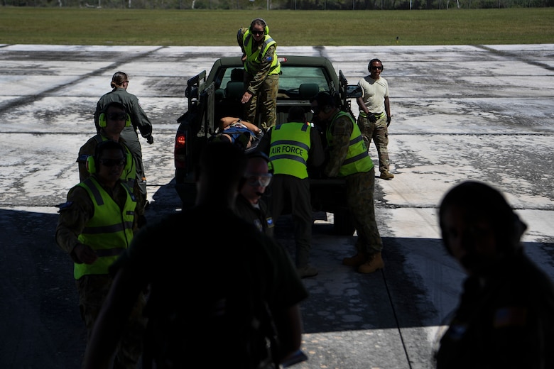 U.S. Air Force Reserve Airmen receive help from Royal Australian Air Force members with loading simulated patients onto a truck during an aeromedical mission at Saipan, U.S. Commonwealth of the Northern Mariana Islands, during exercise COPE NORTH 18, Feb. 19.
