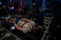 U.S. Air Force Airmen from the 439th and 349th Aeromedical Evacuation Squadrons treat a simulated patient during an aeromedical mission over Rota, U.S. Commonwealth of the Northern Mariana Islands, during exercise COPE NORTH 18, Feb. 19, 2018. The Pacific Air Forces-sponsored tri-lateral field training exercise is designed to develop synergistic and increase interoperability of U.S. Air Forces, Royal Australian Air Force, the Republic of Korea Air Force, and the Japanese Air Self-Defense Force. (U.S. Air Force photo by Staff Sgt. Corey Hook)