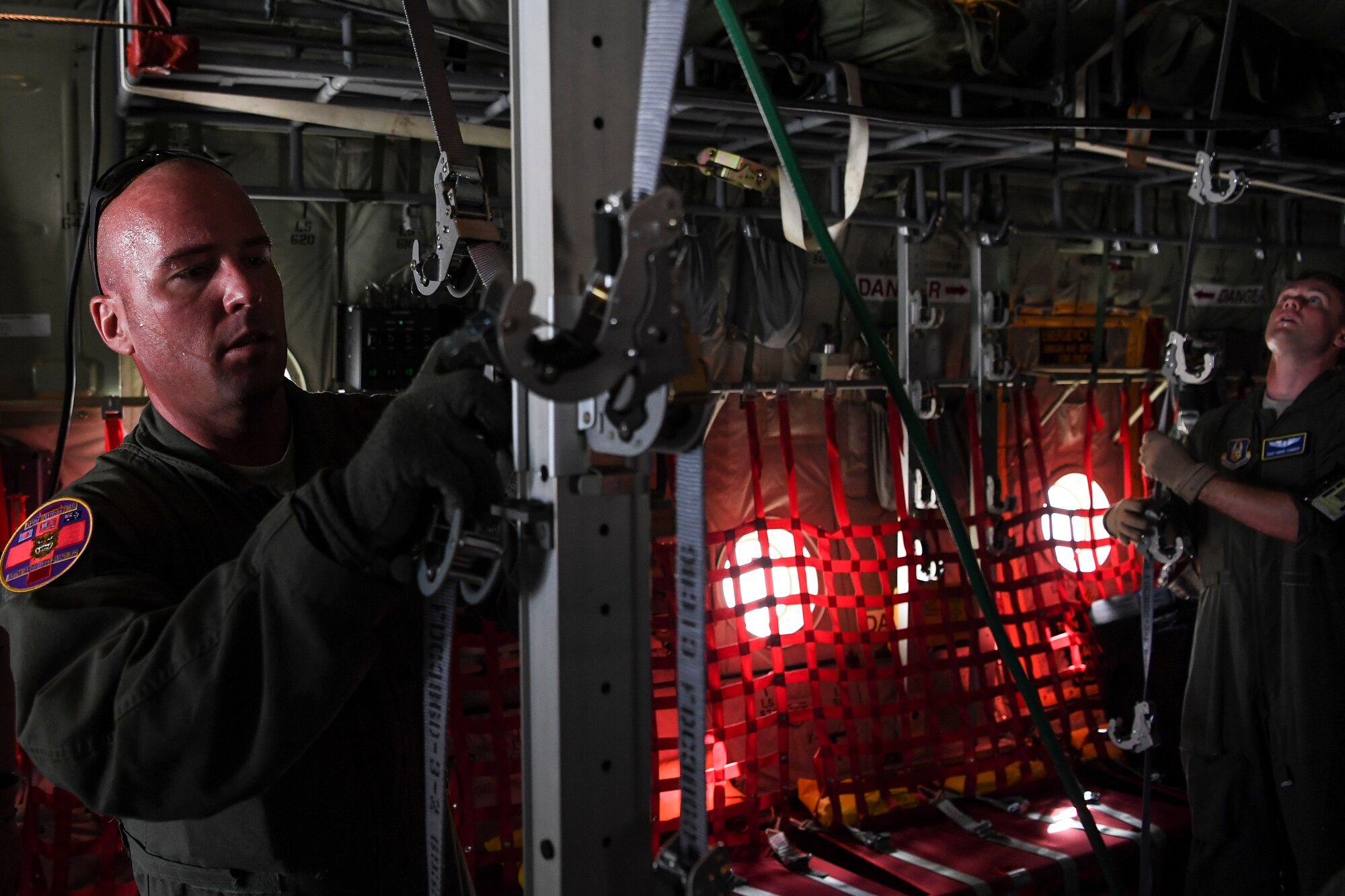 (Left) U.S. Air Force Master Sgt. Ryan McClellan, 36th Aeromedical Evacuation Squadron technician, and Staff Sgt. David Francis, 349th Aeromedical Evacuation Squadron technician, configure the inside of a U.S. Air Force C-130J Super Hercules for an aeromedical mission at Andersen Air Force Base, Guam, during exercise COPE NORTH 18, Feb. 19.