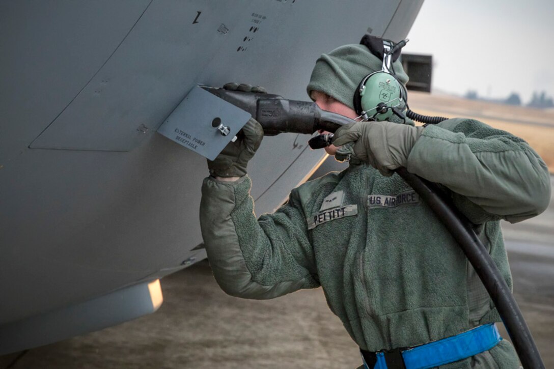Airman 1st Class James Pettitt, 374th Aircraft Maintenance Squadron crew chief, connects an aircraft generator