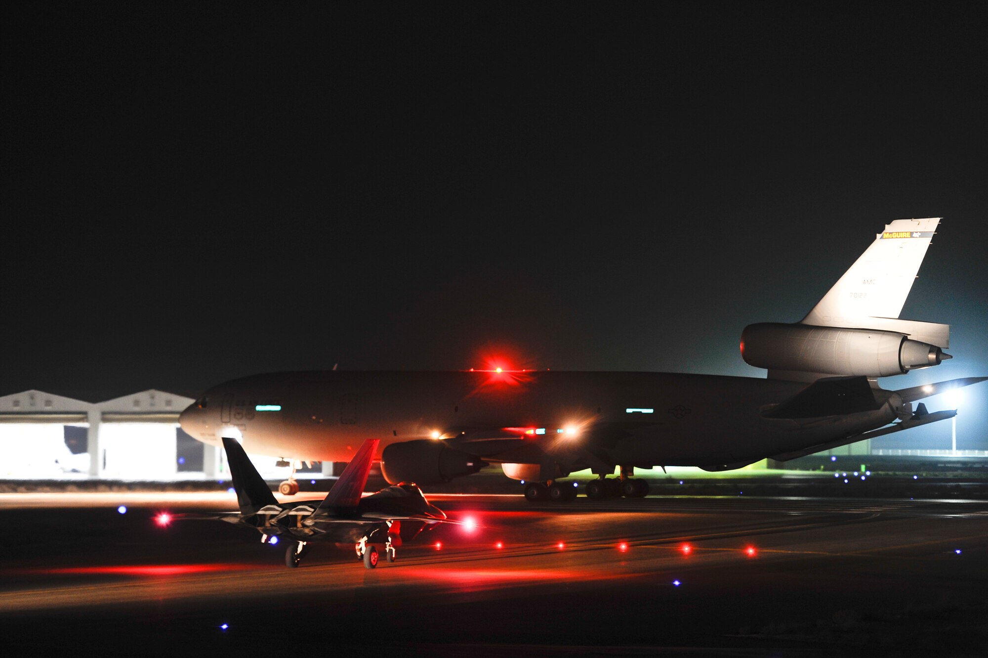 An U.S. Air Force KC-10 Extender and a F-22 Raptor assigned to the 380th Air Expeditionary Wing, Al Dhafra Air Base, Unite Arab Emirates taxi down the runway before departing on a mission in support of Operation Inherent Resolve, Feb. 13, 2018. The name Inherent Resolve is intended to reflect the unwavering resolve and deep commitment of the U.S. and partner nations in the region and the wider international community.
 (U.S. Air Force photo by Tech. Sgt. Anthony Nelson Jr.)
