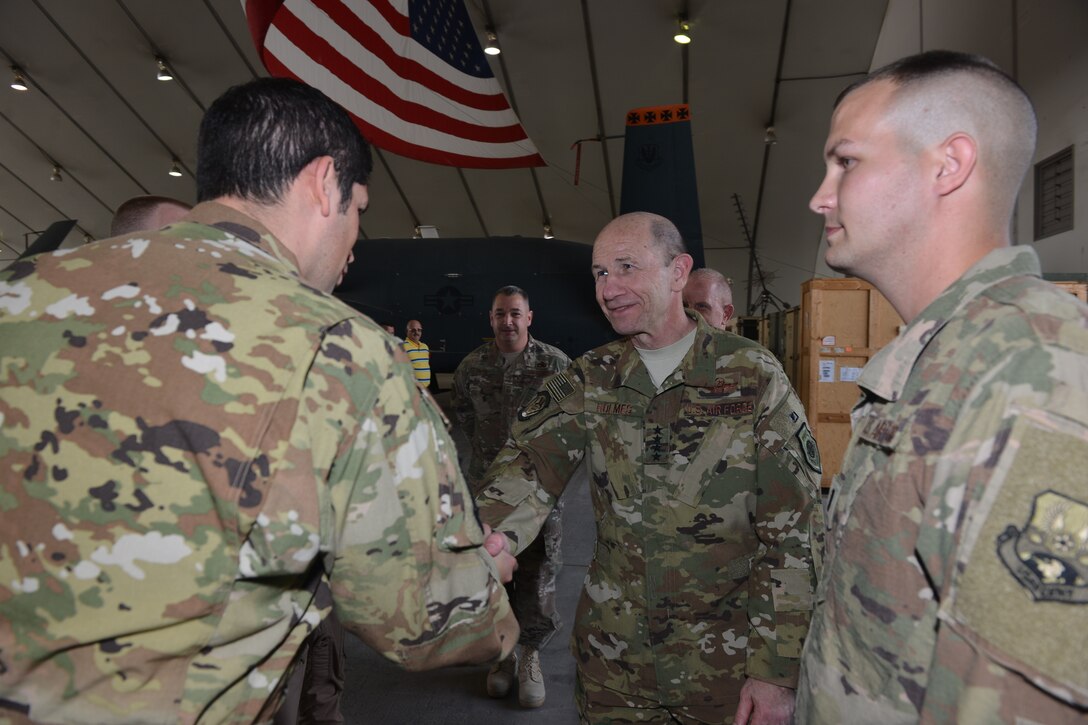 U.S. Air Force Gen. Mike Holmes, commander of Air Combat Command  coins Maj. Manuel Ochoa, an RQ-4 pilot assigned to the 380th Air  Expeditionary Wing, Al Dhafra Air Base, United Arab Emirates for being an  outstanding performer Feb. 11, 2018. Ochoa flew the RQ-4 Global Hawk which  recently logged over 20,000 flight hours while being assigned to the 380th
 AEW. 
 (U.S. Air Force photo by Tech. Sgt. Anthony Nelson J.R.)