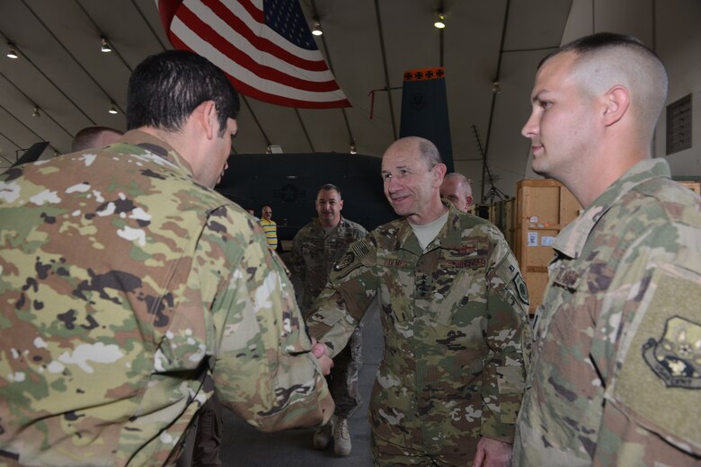 U.S. Air Force Gen. Mike Holmes, commander of Air Combat Command  coins Maj. Manuel Ochoa, an RQ-4 pilot assigned to the 380th Air  Expeditionary Wing, Al Dhafra Air Base, United Arab Emirates for being an  outstanding performer Feb. 11, 2018. Ochoa flew the RQ-4 Global Hawk which  recently logged over 20,000 flight hours while being assigned to the 380th
 AEW. 
 (U.S. Air Force photo by Tech. Sgt. Anthony Nelson J.R.)