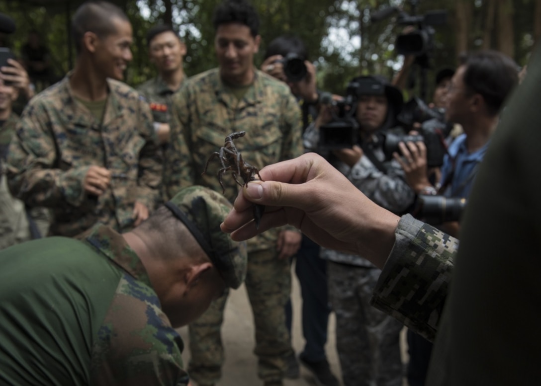 Marines get ready to eat a scorpion.