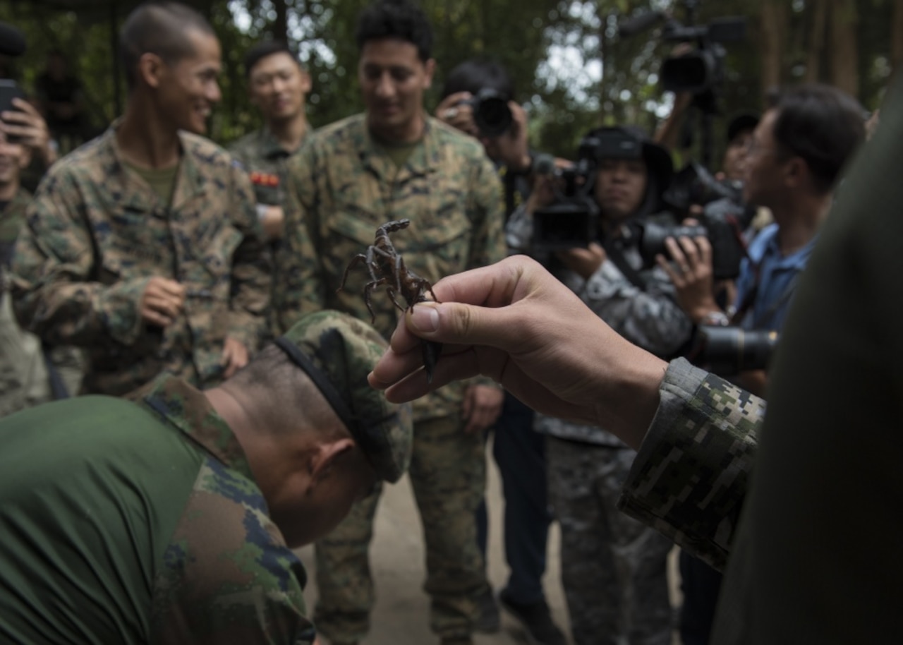 Marines get ready to eat a scorpion.