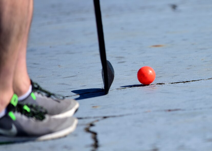 AA member of Team Whiteman prepares to hit the ball during the first extramural hockey practice at Whiteman Air Force Base, Mo., Feb. 17, 2018. Until there is more interest in the sport, the teams will continue to play in shoes and with street hockey gear. (U.S. Air Force photo by Staff Sgt. Danielle Quilla)