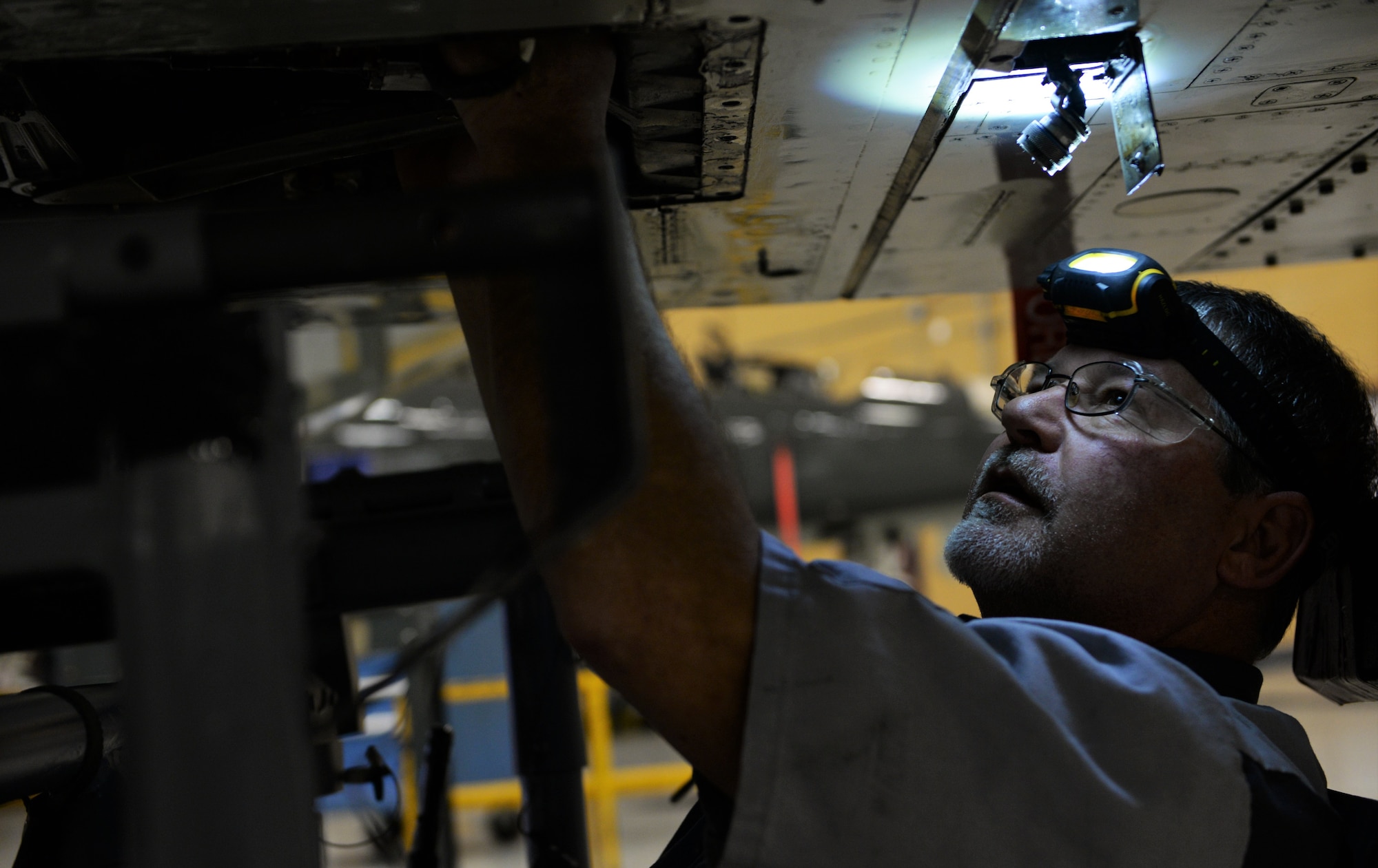 Steve Henderson, L3 Technologies T-38C Talon maintainer, finishes switching the stability augmentation system on a T-38 Feb. 14, 2018, on Columbus Air Force Base, Mississippi. Maintainers must take the outside hull of the aircraft apart, similar to a shell, to reach pieces such as the engine to complete some of their maintenance. (U.S. Air Force photo by Airman 1st Class Keith Holcomb)