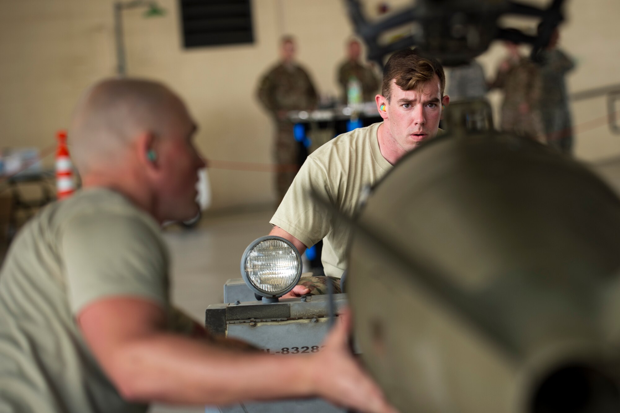 Airman 1st Class Hunter Leger, right, Staff Sgt. Ryan Amos, left, 74th Aircraft Maintenance Unit (AMU) weapons-load crewmembers, places an inert MK-84 general purpose bomb onto an A-10C Thunderbolt II during a weapons-load competition, Feb. 22, 2018 at Moody Air Force Base, Ga. Judges assessed the 75th and 74th AMUs on how quickly and efficiently they loaded munitions onto an A-10C Thunderbolt II during the loading portion of the competition. They were also judged on dress and appearance and a written test based on munition knowledge. (U.S. Air Force photo by Senior Airman Daniel Snider)