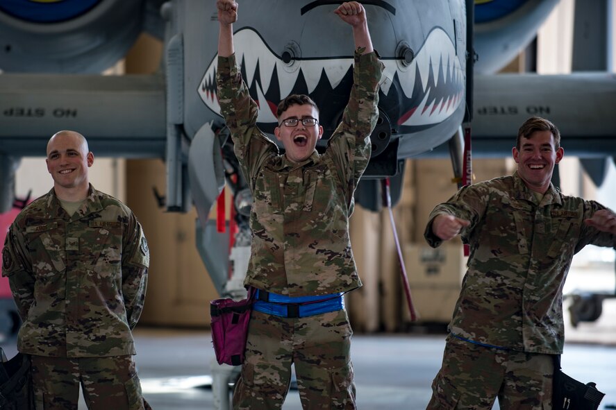 Staff Sgt. Ryan Amos, left, Airman 1st Class Joseph Capshaw, center, and Airman 1st Class Hunter Leger, all 74th Aircraft Maintenance Unit (AMU) weapons load crewmembers, celebrate after winning a weapons-load competition, Feb. 22, 2018 at Moody Air Force Base, Ga. Judges assessed the 75th and 74th AMUs on how quickly and efficiently they loaded munitions onto an A-10C Thunderbolt II during the loading portion of the competition. They were also judged on dress and appearance and a written test based on munition knowledge. (U.S. Air Force photo by Senior Airman Daniel Snider