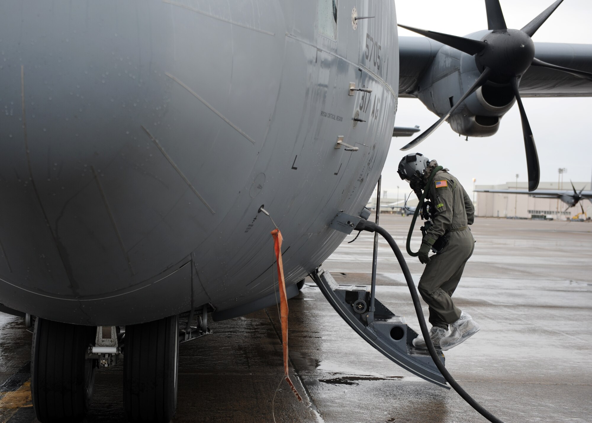 A male boards a grey C-130J.