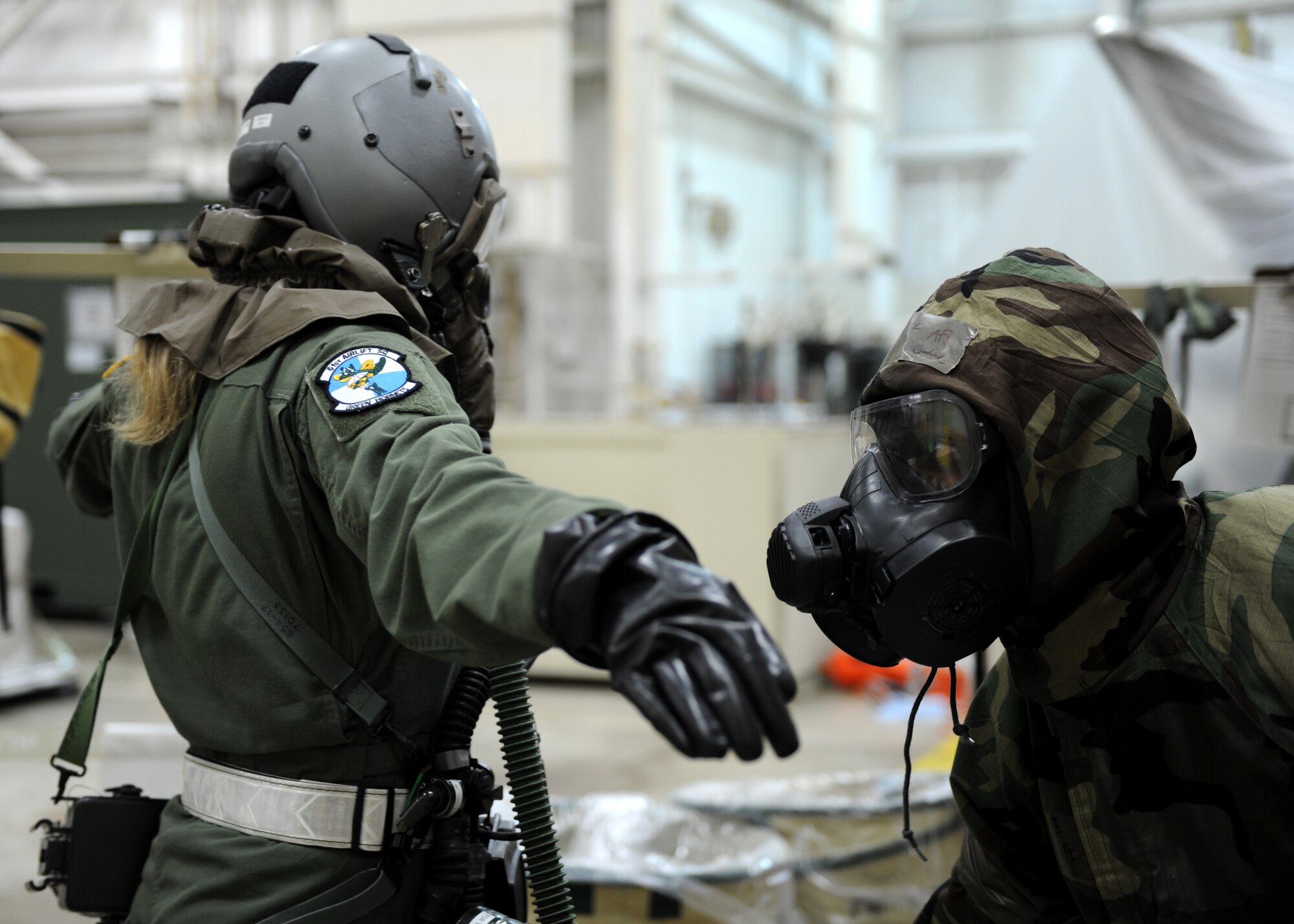 A male assists a female with a mock decontamination process.